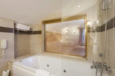 a bathroom with a bath tub and a window at Ottoman Hotel Imperial-Special Category in Istanbul