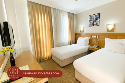 a hotel room with two beds and a desk at Sude Konak in Istanbul