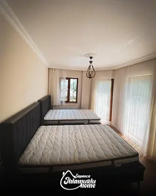 two beds in a bedroom with two windows at Ihlamurlu Home in Sapanca