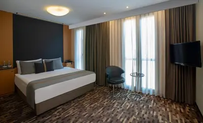 a hotel room with a bed and a tv and window at Tan Hotel - Special Category in Istanbul