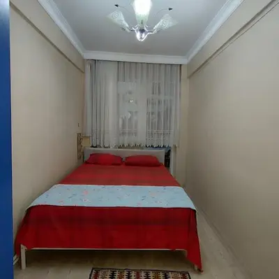 a bedroom with a red bed and a chandelier at Nur home1 in Istanbul