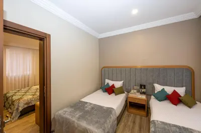 a hotel room with two beds and a mirror at Grand Anka Hotel in Istanbul