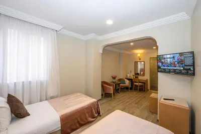 a hotel room with two beds and a television at Grand Anka Hotel in Istanbul