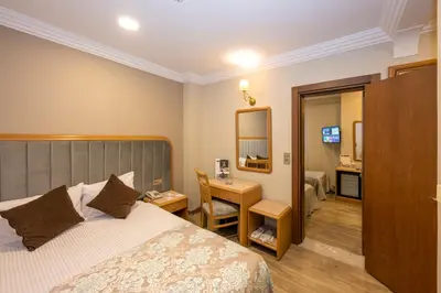 a bedroom with a bed and a desk and a mirror at Grand Anka Hotel in Istanbul