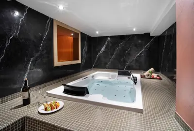 a bath tub in a bathroom with a bottle of wine at Orka Royal Hotel & Spa in Istanbul