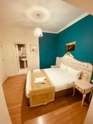 a bedroom with a large bed and a blue wall at Adora Hotel in Istanbul