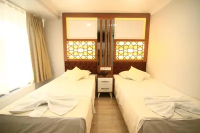 two beds in a room with two windows at Grand Liza Hotel in Istanbul