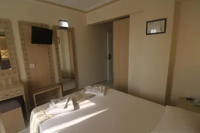 a bedroom with a white bed and a mirror at Grand Liza Hotel in Istanbul