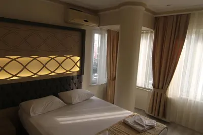 a bedroom with a bed and two windows at Grand Liza Hotel in Istanbul