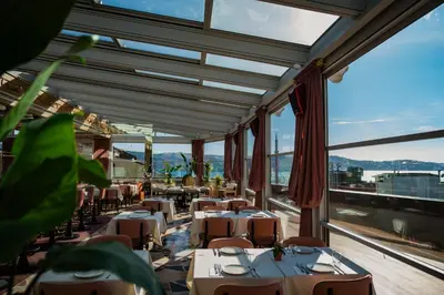 a restaurant with tables and chairs and large windows at Crowne Plaza Istanbul - Ortakoy Bosphorus by IHG in Istanbul
