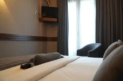 a hotel room with a bed and a chair and a window at Bern Hotel in Istanbul