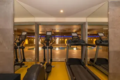 a gym with tread machines and a mirror at Ramada By Wyndham Istanbul Pera Taksim in Istanbul