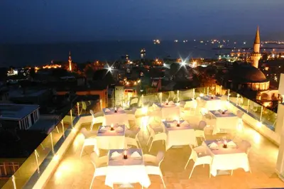 a group of tables and chairs on a balcony at night at Hotel Daphne in Istanbul