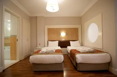 a bedroom with two beds and a bathroom at Taksim Metropark Hotel in Istanbul