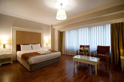 a hotel room with a bed and a chair and a table at Taksim Metropark Hotel in Istanbul