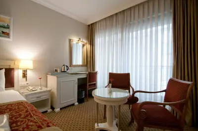 a hotel room with a bed and a table and a sink at Taksim Metropark Hotel in Istanbul
