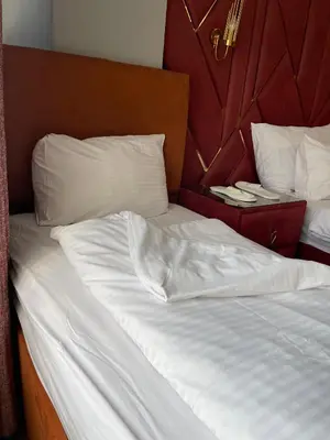 a bed with white sheets and pillows in a room at Aymira Suite Hotel in Istanbul