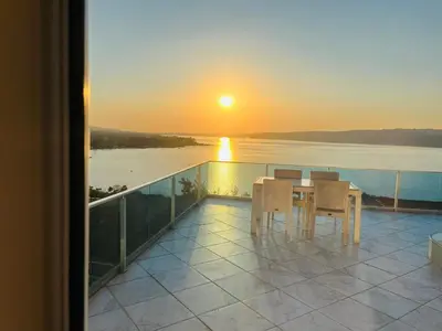 a table and chairs on a balcony with a sunset at WHİTE ROSE VİLLA Jakuzili ve Isıtma Havuzlu in Sapanca