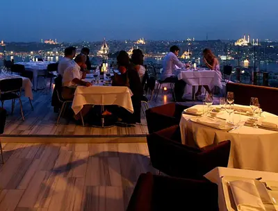 a group of people sitting at tables in a restaurant at The Marmara Pera in Istanbul
