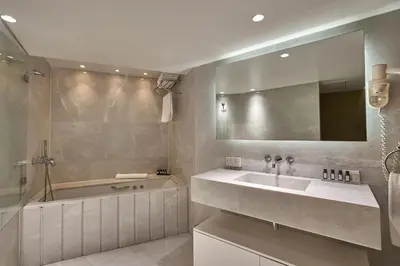a bathroom with a sink and a tub and a mirror at The Marmara Pera in Istanbul