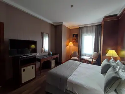 a hotel room with a large bed and a television at The Green Park Bostancı in Istanbul