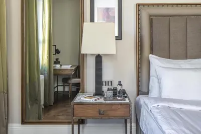 a bedroom with a bed and a table with a lamp at The Bank Hotel Istanbul, a Member of Design Hotels in Istanbul