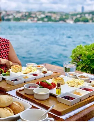a table with food on it with the ocean in the background at A'jia Hotel in Istanbul