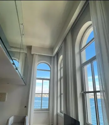 a living room with two large windows and the ocean at A'jia Hotel in Istanbul