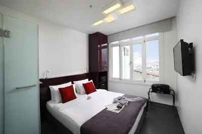a bedroom with a bed with red pillows and a television at The Central House Istanbul Taksim in Istanbul