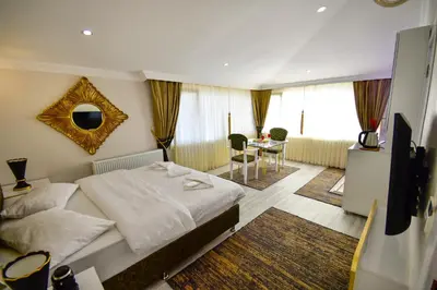 a bedroom with a bed and a tv and a table at LOCA Suit LİFE AİRPORT HOTEL in Istanbul
