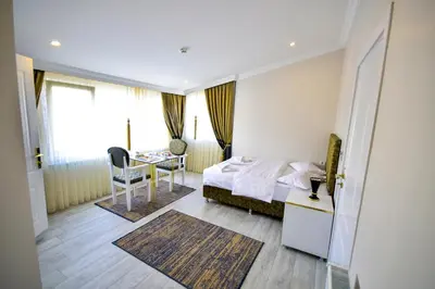 a bedroom with a bed and a desk and a table at LOCA Suit LİFE AİRPORT HOTEL in Istanbul