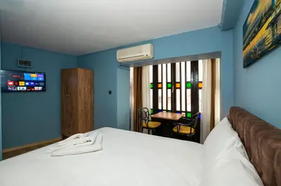 a bedroom with a bed and a table with chairs at Taksim Antique Hotel in Istanbul