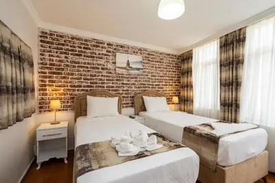 two beds in a room with a brick wall at Blue Mosq- Three Storey Detached Villa in Istanbul