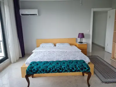 a bedroom with a large bed with a green blanket at KD Apartments in Kartepe