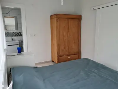 a bedroom with a bed and a wooden cabinet at KD Apartments in Kartepe