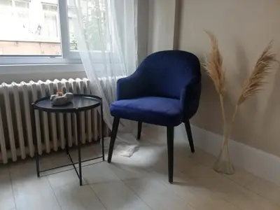 a blue chair and a table next to a window at Osmanbey sweet homes in Istanbul