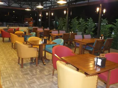 a restaurant with wooden tables and chairs at Çınarpark Hotel in Korfez