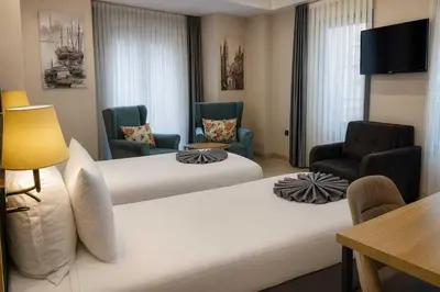 a hotel room with two beds and chairs at Imagine Istanbul - Sultanahmet in Istanbul