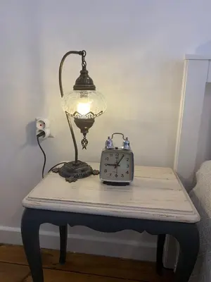 a table with a lamp and an alarm clock on it at Stanbul House in Istanbul