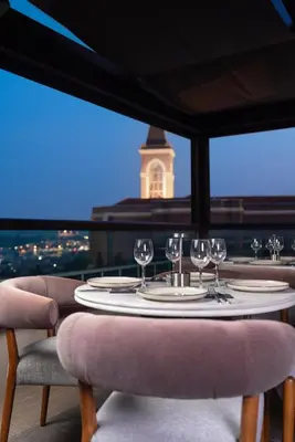 a table with wine glasses and a view of a clock tower at GentleTom in Istanbul