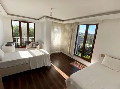 a bedroom with two beds and large windows at Wonderful Villa Airport 5 minutes in Arnavutköy