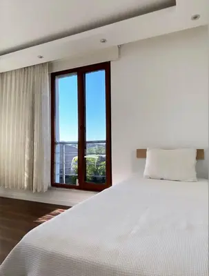 a white bedroom with a large bed and a window at Wonderful Villa Airport 5 minutes in Arnavutköy