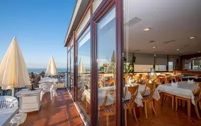 a restaurant with tables and chairs and a view of the ocean at Hotel Erdal in Istanbul