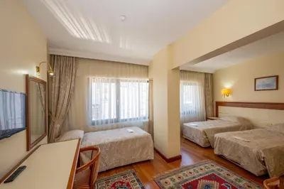 a hotel room with two beds and a desk at Hotel Erdal in Istanbul