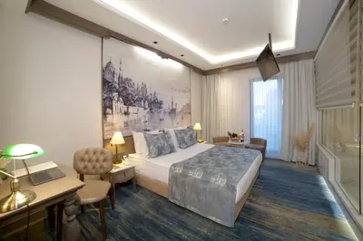 a hotel room with a large bed and a desk and a desk at AHC Ayasofya Hotel - Special Class in Istanbul