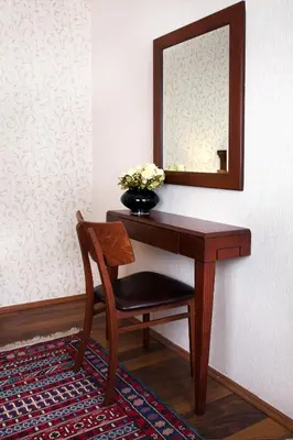 a table with a mirror and a vase of flowers at Sultanahmet Suites in Istanbul