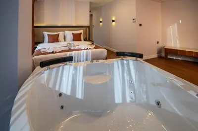 a large bath tub in a room with a bed at Navoris Hotel in Istanbul