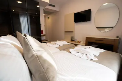 a bedroom with two beds with white pillows and a mirror at Navoris Hotel in Istanbul