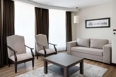 a living room with a couch and two chairs and a table at Ramada Plaza By Wyndham Istanbul City Center in Istanbul