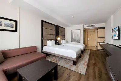 a hotel room with two beds and a couch at Ramada Plaza By Wyndham Istanbul City Center in Istanbul